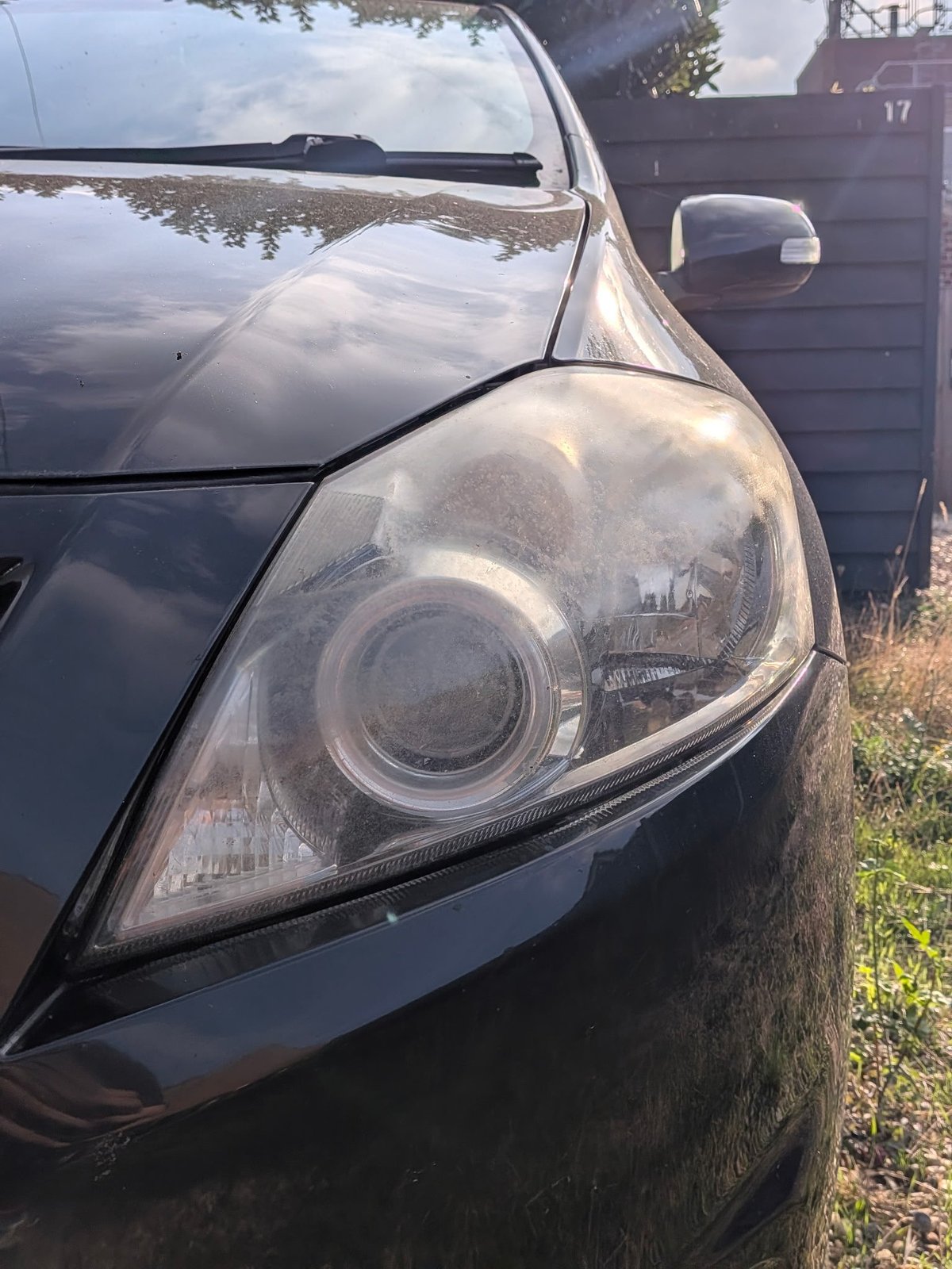 Toyota Auris headlight before restoration — cloudy, faded lens on a black car